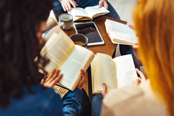 Diverse group of friends discussing a book in library.